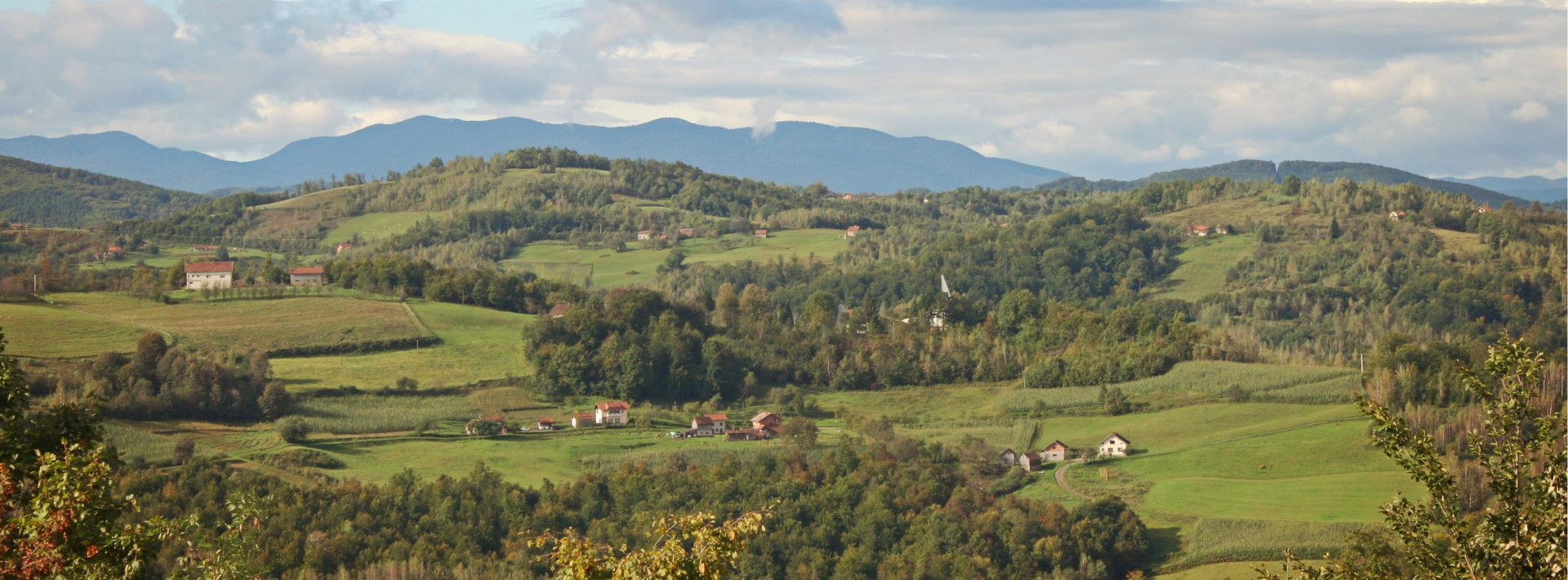 Panorama sela Gornja Ravska okruženog livadama i brdima